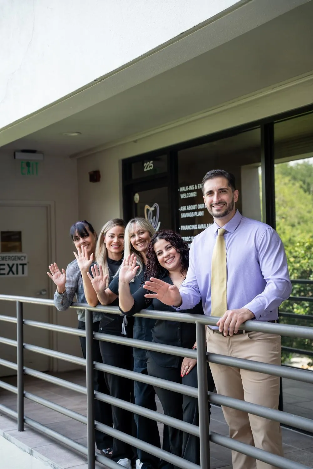The Weston Dental Center team waving from the balcony outside the office
